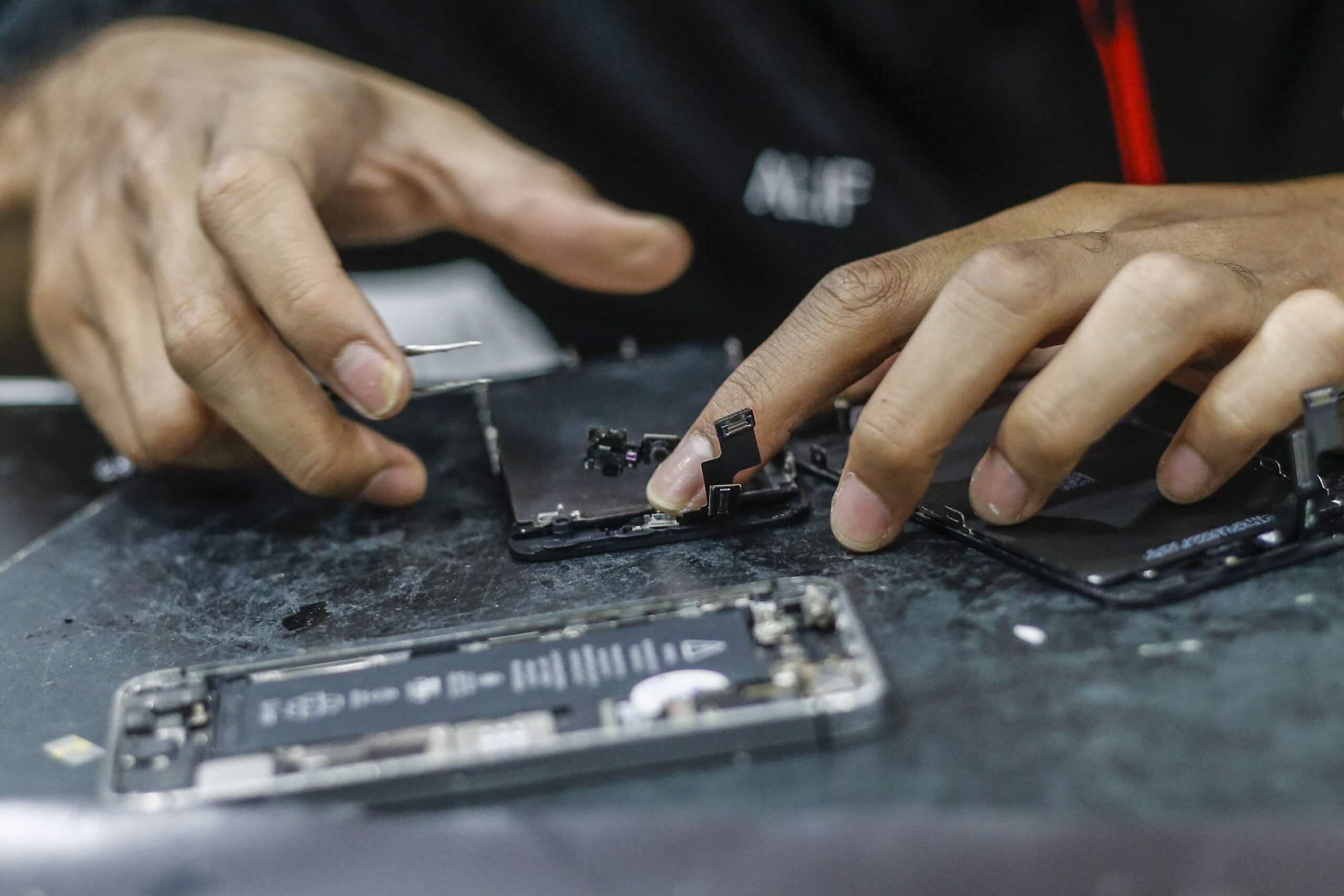 Technician fixing iPhone in Houston at Klein Wireless Phone Repair